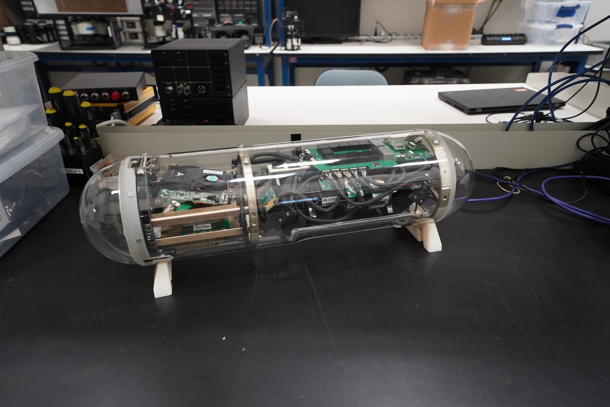 A GeoPod with its cover removed on an integration bench, showing the cameras and electronics inside