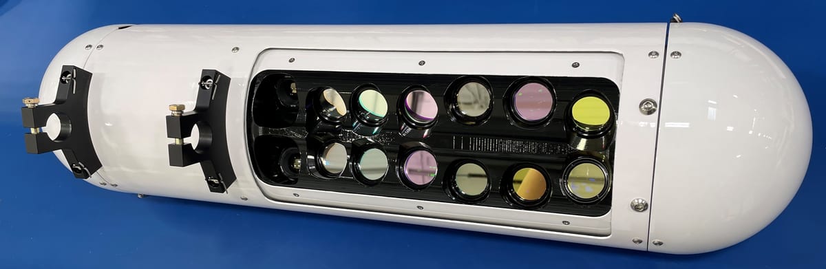 Aeroptic multispectral sensor pod with its window open, showing the camera lenses inside